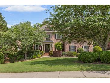 Beautiful brick home with a well-manicured lawn and mature trees at 1440 Water View Ln, Suwanee, GA 30024