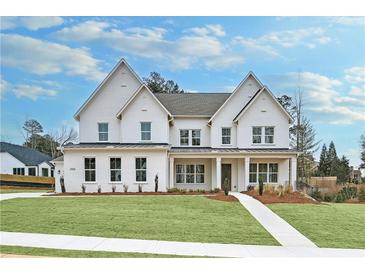Stunning white two-story home with manicured lawn and inviting front porch at 2505 Kirkwood Dr, Cumming, GA 30041