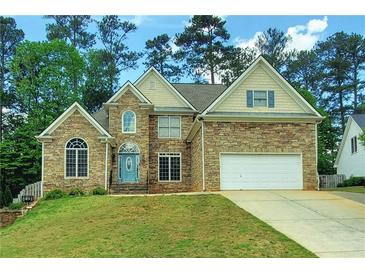 Charming two-story home featuring stone veneer, an attached two-car garage, and a well-manicured lawn at 5881 Brookstone Nw Walk, Acworth, GA 30101
