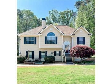 Charming two-story home with a well-manicured lawn, lush landscaping, and welcoming entrance stairs at 3809 Autumn View Nw Ln, Acworth, GA 30101