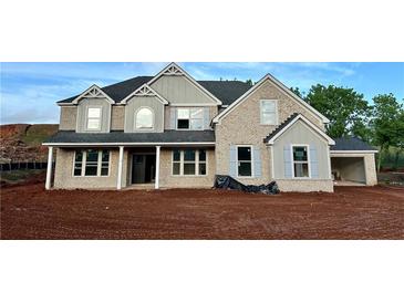 A stately two-story home featuring a brick facade, grey accents, and a charming covered front porch at 4015 Sierra Vista Cir, Cumming, GA 30040