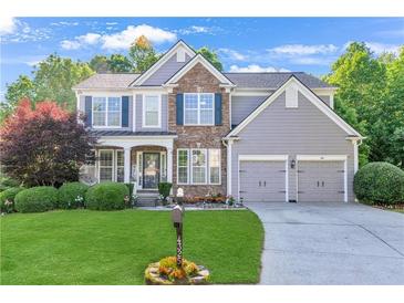 Charming two-story home with stone accents, a well-manicured lawn, and a two-car garage at 4325 Acanthite Ct, Cumming, GA 30040