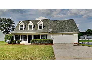 Charming single-Gathering home with a well-manicured lawn, mature trees, and attached two-car garage at 64 Dogwood Rdg, Hampton, GA 30228
