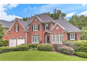 Charming brick home with a well-manicured lawn and lush landscaping in a suburban neighborhood at 3348 Perrington Pointe, Marietta, GA 30066