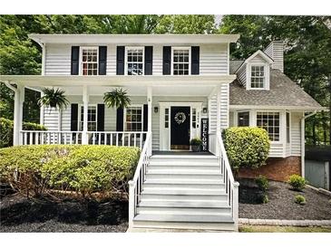 Charming two-story home featuring a welcoming front porch, black shutters, and well-maintained landscaping at 3480 Stillridge Dr, Alpharetta, GA 30022