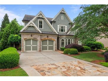 Charming two-story home featuring a beautiful stone driveway, lush landscaping, and an attached two-car garage at 2490 Hillandale Cir, Cumming, GA 30041