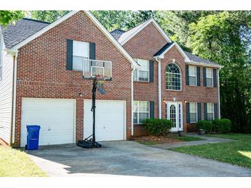 Charming two-story brick home with a well-maintained front yard and a two-car garage at 4041 Smithfield Trl, Ellenwood, GA 30294