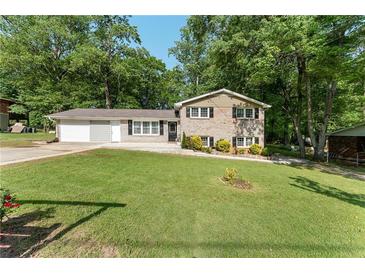 Charming two-story home with a brick facade, well-maintained lawn, and mature trees at 4070 Lauada Dr, Douglasville, GA 30135