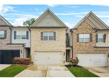 Charming townhomes feature brick exteriors, well-manicured lawns, and attached garages at 241 Irwell Path, Lawrenceville, GA 30044
