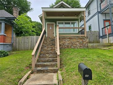 Charming home featuring a stone foundation, a welcoming porch, and a well-maintained front yard at 490 Rockwell Sw St, Atlanta, GA 30310