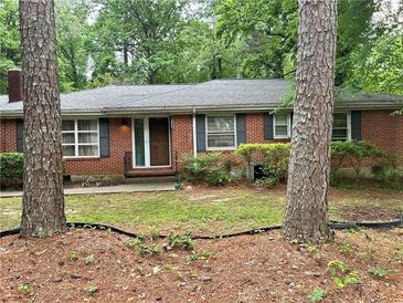 Charming brick home with mature trees and a well-maintained front yard for curb appeal at 5211 Hugh Howell Rd, Stone Mountain, GA 30087