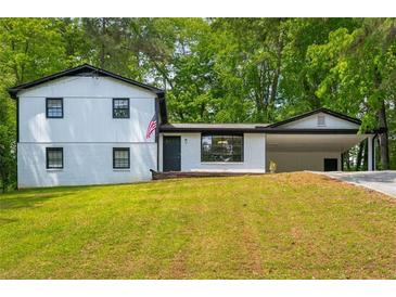 Inviting exterior view of a charming two-story home with manicured lawn and a convenient carport at 157 Jousters Ln, Lawrenceville, GA 30044