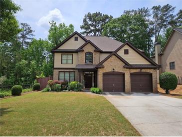 Charming two-story home with a well-manicured lawn and a two-car garage, complemented by lush landscaping at 3943 Dunaire Dr, Stone Mountain, GA 30083