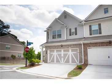 View of a well maintained townhome with two car garage and nicely landscaped front at 532 Walton Dr, Woodstock, GA 30188