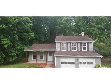 Charming two-story home features an attached two-car garage, gray siding, and mature trees at 991 Park Creek Cir, Lawrenceville, GA 30044