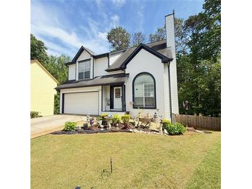 Charming two-story home with a well-manicured front yard and an attached garage at 210 Paris Dr, Lawrenceville, GA 30043