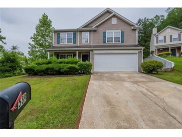 Charming two-story home with lush landscaping, a two-car garage, and welcoming curb appeal at 589 Arbor Ridge Dr, Stone Mountain, GA 30087