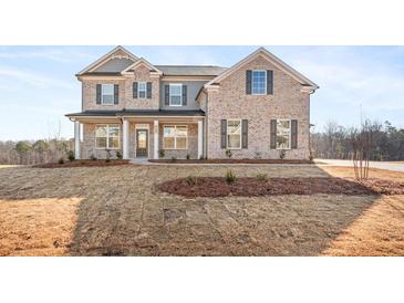 Charming two-story brick home with a welcoming front porch and beautiful architectural details at 727 Hedwig Dr, Mcdonough, GA 30252