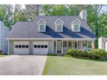 Charming two-story home with a welcoming porch, complemented by a well-maintained lawn and attached two-car garage at 900 Meadowsong Cir, Lawrenceville, GA 30043