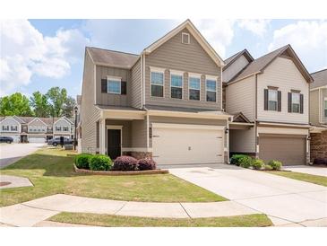 Charming two-story townhome featuring a two-car garage and manicured front lawn with a cozy entrance at 406 Crescent Woode Dr, Dallas, GA 30157