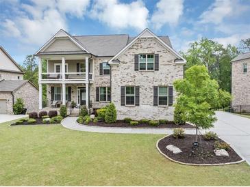 Charming two-story brick home featuring a landscaped lawn, covered porch and a two-car garage at 5075 Briarstone Ridge Way, Alpharetta, GA 30022
