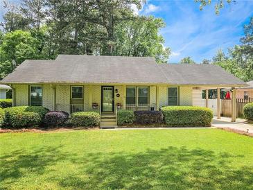 Charming single-story home with well-manicured lawn, mature shrubs, and covered parking at 2413 Hunting Valley Dr, Decatur, GA 30033