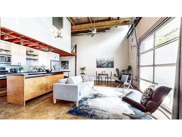Bright, open-concept living room featuring hardwood floors and a modern kitchen with stainless steel appliances at 1661 La France Ne St # 221, Atlanta, GA 30307