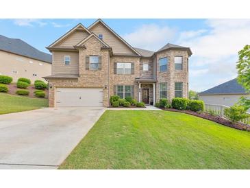 Charming two-story home with brick and tan siding, a well-manicured lawn, and an attached two-car garage at 197 Hickory Pointe Dr, Acworth, GA 30101