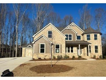 Beautifully landscaped two-story home with a stone and siding exterior and an attached two-car garage at 4040 Sierra Vista Cir, Cumming, GA 30040