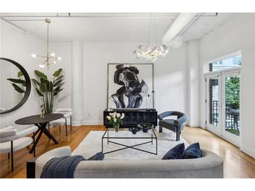 Bright living room features modern lighting, hardwood floors, stylish furniture, and large abstract art at 1058 Piedmont Ave # 103, Atlanta, GA 30309