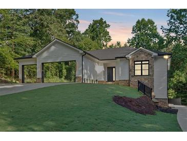 Charming one-story home featuring a side entry garage, stone accents, and lush landscaping at 507 Karen Ln, Woodstock, GA 30188