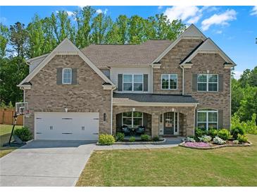 Charming brick two-story home featuring a well-manicured lawn, covered entryway, and attached two-car garage at 319 Parkside Meadow Dr, Marietta, GA 30064
