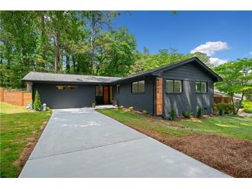 Charming brick home featuring a well-manicured lawn and a concrete driveway at 3964 Gretna Green Dr, Decatur, GA 30035
