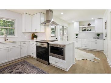 Bright kitchen features white cabinets, stainless steel appliances, and modern finishes at 605 Patrick Ne Pl, Sandy Springs, GA 30328