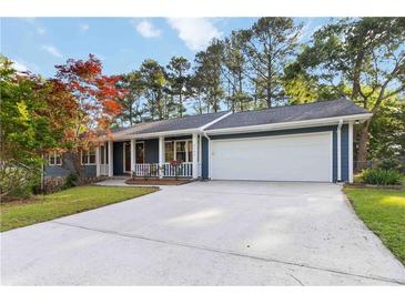 Charming home featuring blue siding, white trim, a spacious driveway, and a manicured lawn at 2142 Graystone Pkwy, Grayson, GA 30017