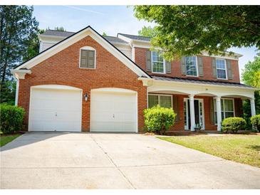 Charming two-story brick home with a two-car garage, inviting front porch and manicured lawn in a residential neighborhood at 663 Prada Ct, Lawrenceville, GA 30043