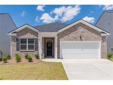 Charming brick home featuring a two-car garage, well-maintained lawn, and inviting entrance at 2010 Vidalia Ct, Dacula, GA 30019