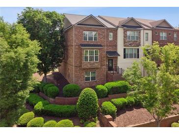 Charming brick townhome with well-maintained landscaping and manicured bushes at 2020 Jardin Ct, Alpharetta, GA 30022