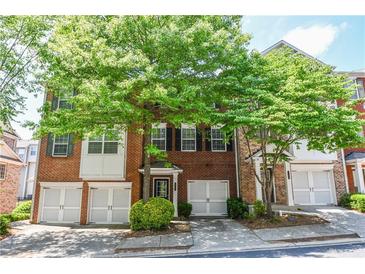 Charming brick townhome with a one-car garage and mature trees in a well-maintained community at 2201 Landing Walk Dr, Duluth, GA 30097