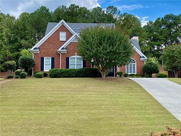 Charming red brick home with a well-manicured lawn and mature trees at 1093 Spruce Creek Ln, Lawrenceville, GA 30045