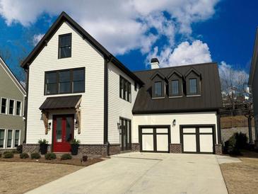Beautiful two-story modern farmhouse featuring a red front door, two-car garage, and manicured landscaping at 7275 Cordery Rd, Cumming, GA 30040
