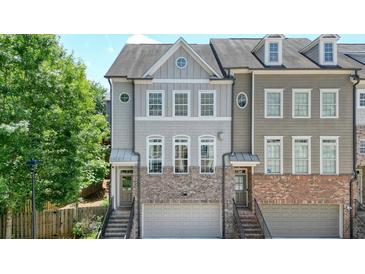 Charming townhome with gray and brick exterior, front-entry garage, and well-maintained landscaping at 2093 Callaway Nw Ct, Atlanta, GA 30318