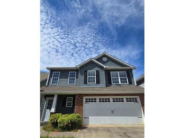Charming two-story home with blue siding, black shutters, brick accents, and a two-car garage at 28 Samuel Nw Way, Cartersville, GA 30121