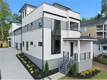 Modern three-story home featuring a white and gray exterior with manicured landscaping at 90 Cleveland Unit A Se St, Atlanta, GA 30316