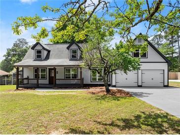 Charming two-story home with a welcoming front porch and a convenient two-car garage at 2979 Overwood Sw Ln, Snellville, GA 30078