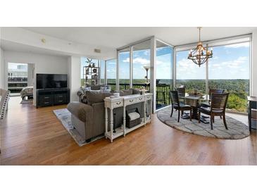 Bright living room features hardwood floors, floor to ceiling windows, neutral colors, and a decorative fireplace at 3300 Windy Ridge Se Pkwy # 1401, Atlanta, GA 30339