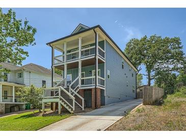 Two-story home boasting dual porches, blue siding, and a private driveway at 632 Warren Ave, Scottdale, GA 30079