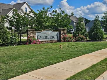Stone sign surrounded by flowers and greenery marks the Everleigh neighborhood entrance at 125 Leveret Rd, Locust Grove, GA 30248