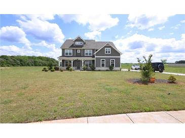 Two-story home featuring gray siding, a covered porch, and large front yard at 125 Leveret Rd, Locust Grove, GA 30248