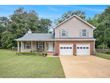 Charming two-story home with a well-manicured lawn, two-car garage, and covered front porch at 4326 Megan Manor Sw Dr, Powder Springs, GA 30127